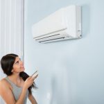 young woman turning on ac
