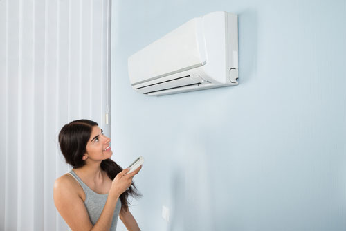 young woman turning on ac
